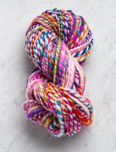 multicolored skeins of yarn on a marble surface