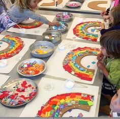 several children are sitting at a table working on their art project with paper plates and bowls