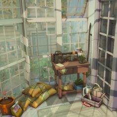 a room with lots of windows and plants on the table in front of some bags