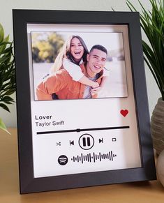 a black and white photo frame sitting on top of a table next to a potted plant