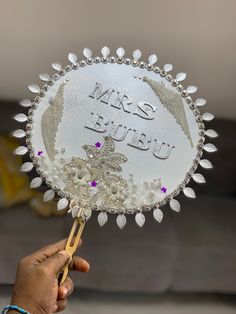 a person holding up a glass plate with beads and jewels on it that says, i love you