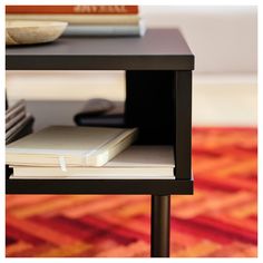 a table with a laptop and books on it in front of a carpeted area