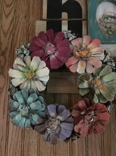 a wreath made out of flowers sitting on top of a wooden table