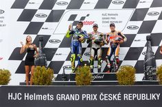 three people standing on top of a race podium