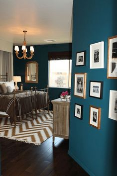 a bedroom with teal walls and pictures on the wall