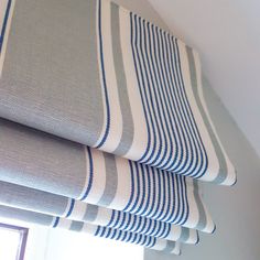 a close up of a roman blind with blue and white stripes