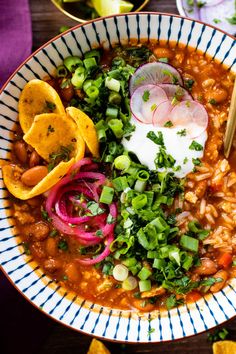 a bowl filled with beans, onions and tortilla chips