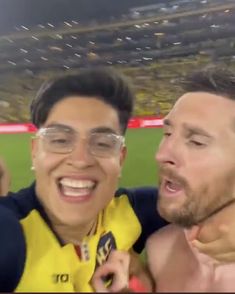 two men standing next to each other at a soccer game