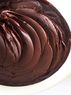 a white bowl filled with chocolate frosting on top of a table