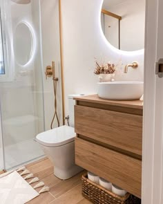 a bathroom with a sink, toilet and shower stall in the background is a mirror