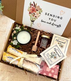 an open box containing soaps, honey and candles