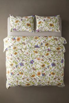 an image of a bed with flowers and leaves on the comforter in front of it