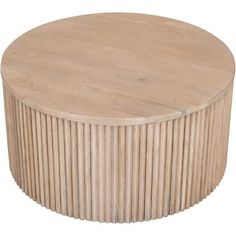 a round wooden table sitting on top of a white floor covered in wood slats