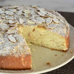 a cake that is on a plate with some powdered sugar on top and one slice missing