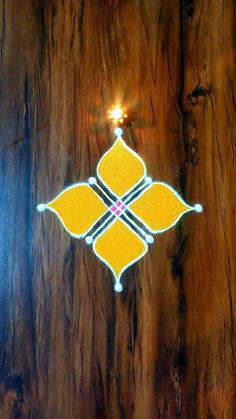 a wooden table with a lit candle in the center and an intricate design on it