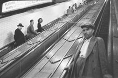 people are riding on an escalator at the subway station in black and white