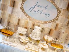 a table topped with lots of cupcakes and desserts next to a sign