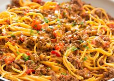 spaghetti with meat and vegetables in a white bowl