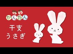 two paper rabbits are standing next to each other on a red background with japanese characters