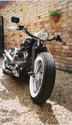 a motorcycle parked next to a brick wall