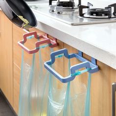 a kitchen counter with plastic bags hanging from it's handles