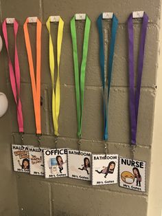 colorful lanyards are hanging on the wall in a bathroom with name tags attached to them