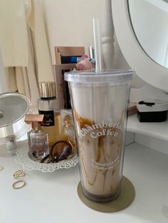 a coffee cup sitting on top of a counter next to a mirror and other items