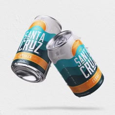 two cans of santa cruz energy drink are flying through the air in front of a white background