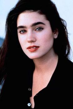 a close up of a person wearing a black shirt and long hair with blue eyes