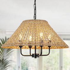 a chandelier hanging from a ceiling in a living room with windows and potted plants