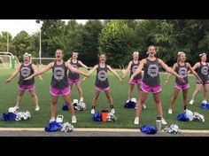 a group of cheerleaders standing on top of a field