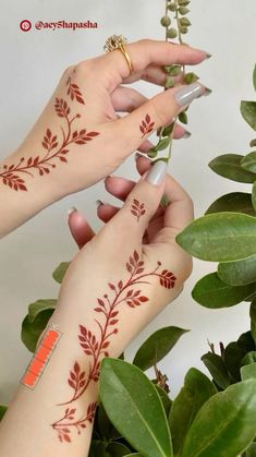 two hands with hendi tattoos on their fingers