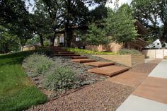 the steps lead up to the house from the grass and trees in the front yard