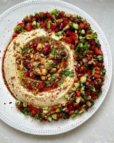 a white plate topped with hummus and vegetables