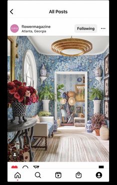 a living room filled with lots of furniture and flowers on the wall next to a doorway