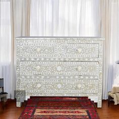 a white dresser sitting on top of a wooden floor