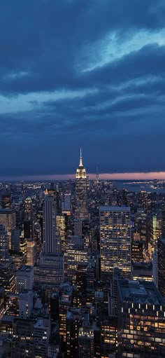 the city skyline is lit up at night, with skyscrapers in the foreground