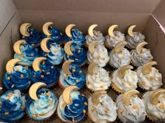 a box filled with cupcakes covered in blue and white frosting