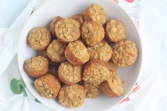 a bowl filled with muffins sitting on top of a white cloth covered table