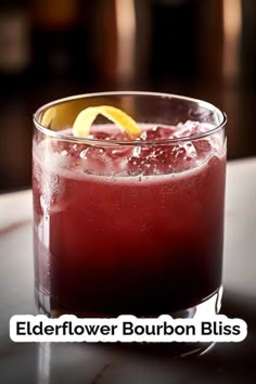 a close up of a drink in a glass on a table with the words elderflower bourbon bliss