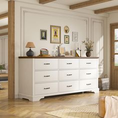 a large white dresser sitting in a living room next to a lamp and pictures on the wall