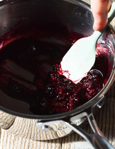 a spoon in a pot filled with red liquid