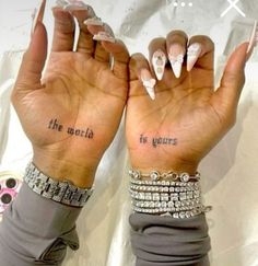 two hands with tattoos on their fingers and the words,'the world is yours '