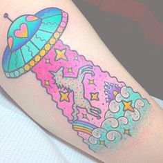 a colorful tattoo on the leg of a woman with an alien spaceship and stars in it