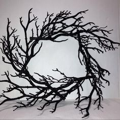 a sculpture made out of branches on a white surface