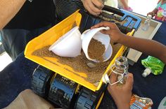 a child is playing with sand in a cart