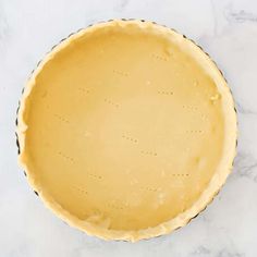 an uncooked pie crust on a marble counter top