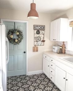 a white kitchen with black and white tile flooring