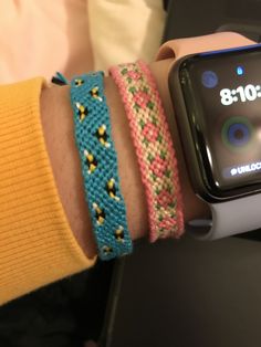 two people wearing bracelets on their wrist with an apple watch in the foreground