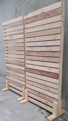 two wooden slatted boards sitting next to each other on the ground in front of a wall